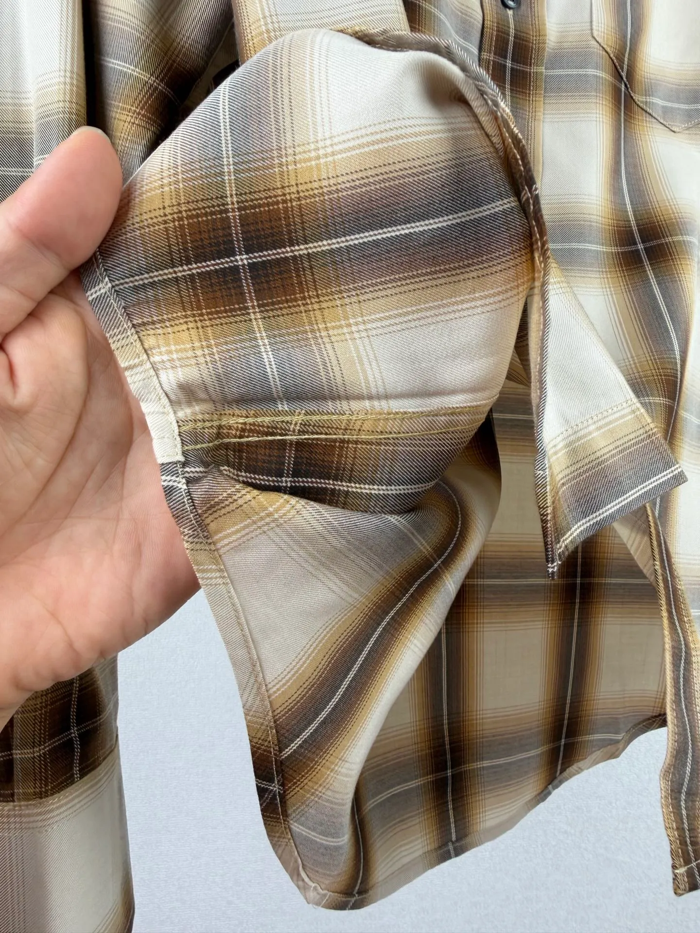 AMI Paris embroidered plaid long-sleeved shirt. Customized cloud-like Lyocell plaid Canvas. Soft and draped. Breathable. Warm brown and Cream White gradients intertwine to form a misty plaid pattern. It is like the spring morning light flowing through the texture. It is warm and relaxed. The small chest pocket is embroidered with AMI's signature small love heart. The brand logo is hidden with fine stitching. It is low-key but powerful. There is an undercurrent of light luxury style in the white space. Perfectly interpreting the exquisite balance of French relaxation and old money style. Process 1: Using imported machine embroidery technology, using advanced computer control systems and precision mechanical components to realize Ami love embroidery operations with high precision and smooth and delicate lines. Process 2: Infrared positioning cutting machine uses infrared transmitters and infrared receivers to achieve precise positioning of materials. The accuracy can reach the micron level, thereby meeting the effect of high-precision cutting of plaid alignment and strip alignment. Process 3: The fabrics have been fermented and washed, giving a better hand feel. Not easy to deform, not easy to shrink, not easy to fade, maintain long-term beauty Accessories: Customized 1:1 Ami buttons Customized 1:1 Ami trademark Version: Loose version Size: 38 39 40 41